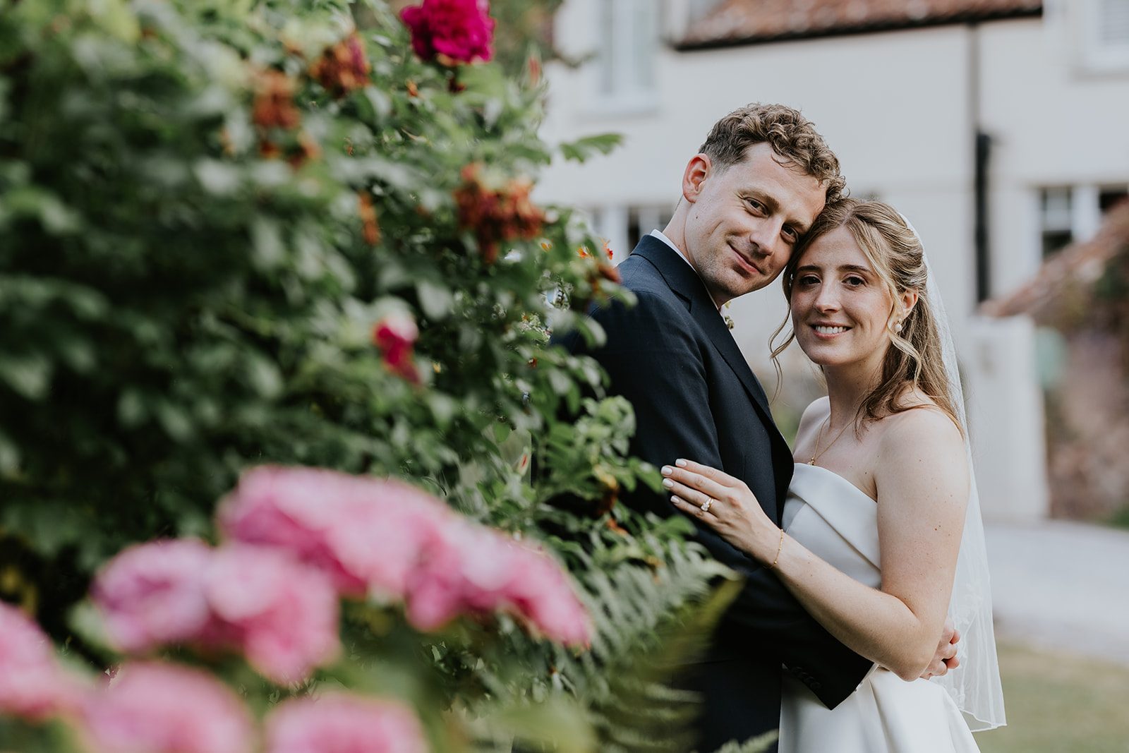 Anna and Alex together among the pink flowers at Combe House Hotel