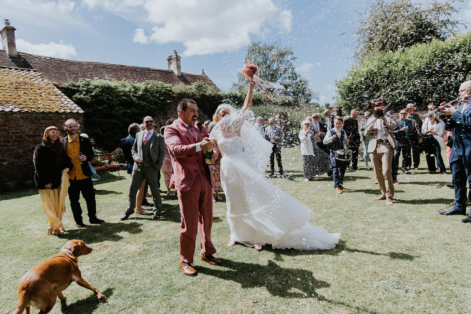 Barney and Ellie opening champagne with spray flying through the air