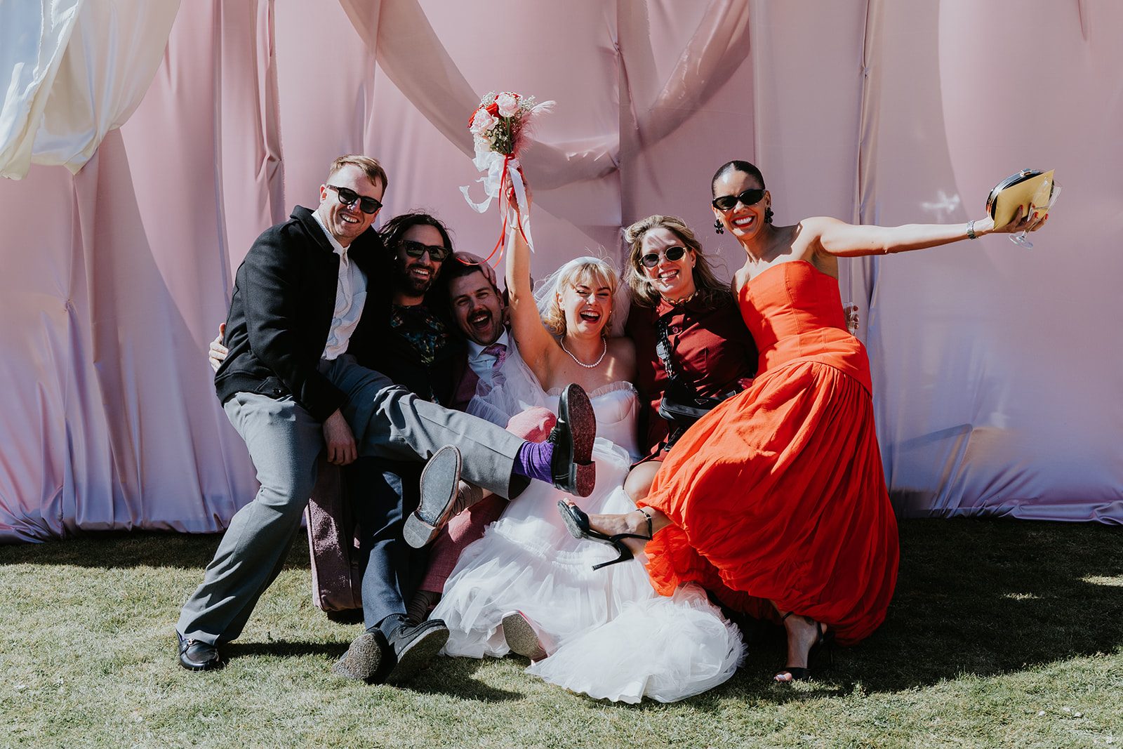 Barney and Ellie celebrating with friends in a playful bridal-party photograph