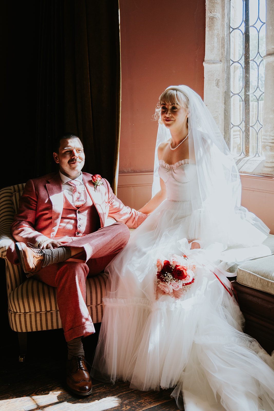 Barney and Ellie sitting together in soft window light at Cothelstone Manor