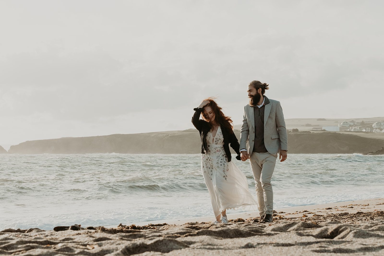 A couple walking hand in hand beside the sea