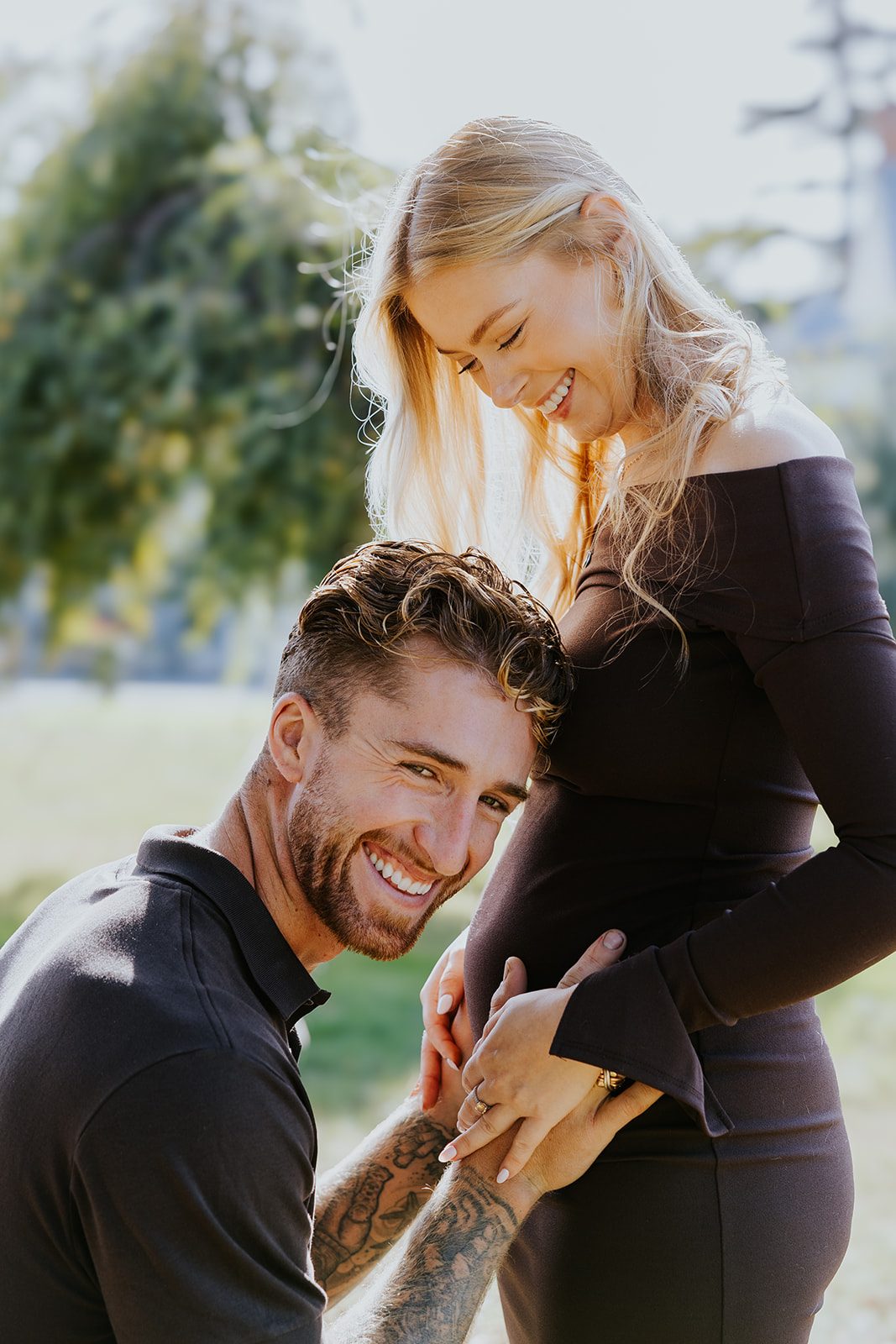 A couple smiling together during their maternity shoot