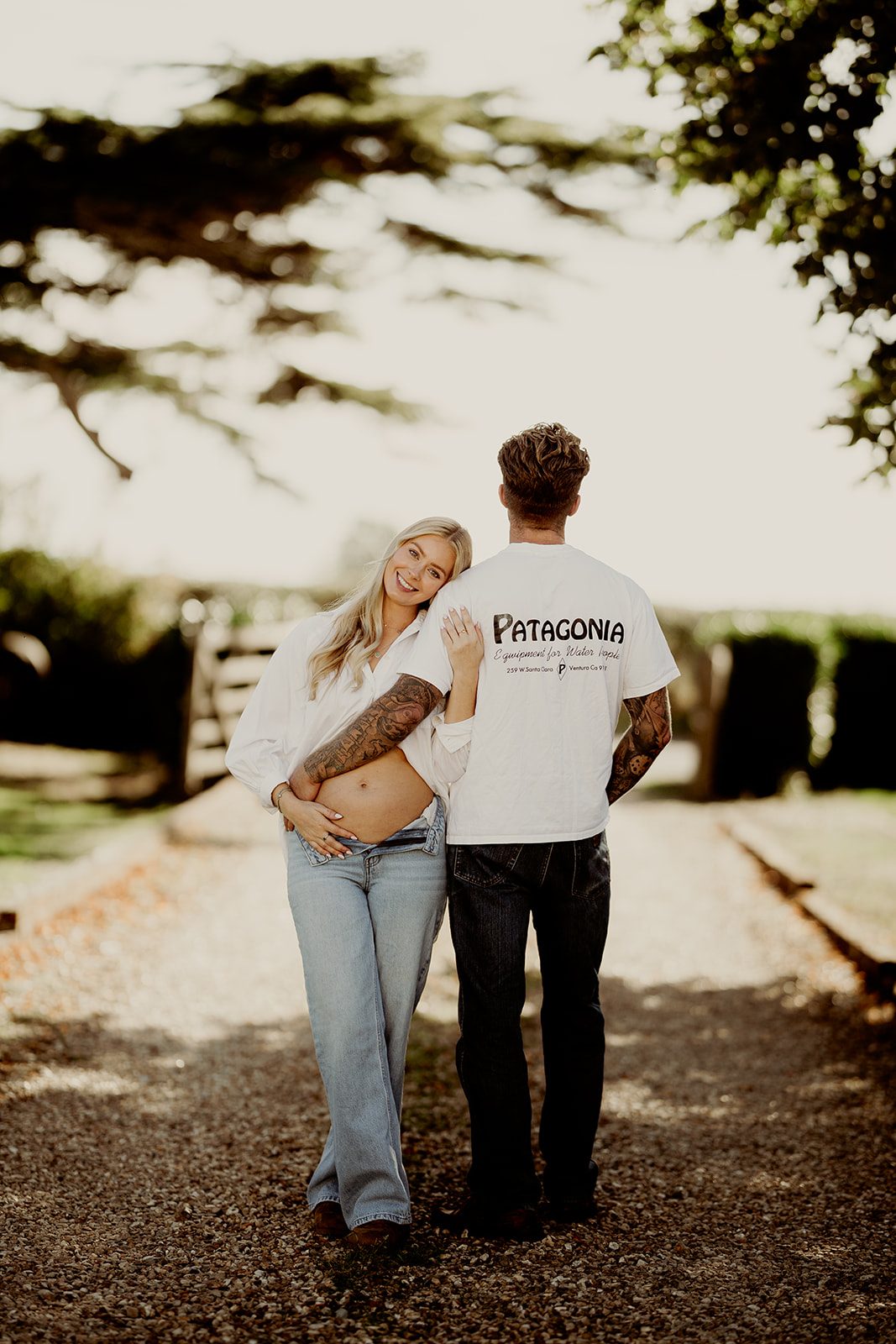 An expectant couple enjoying a relaxed moment together outdoors