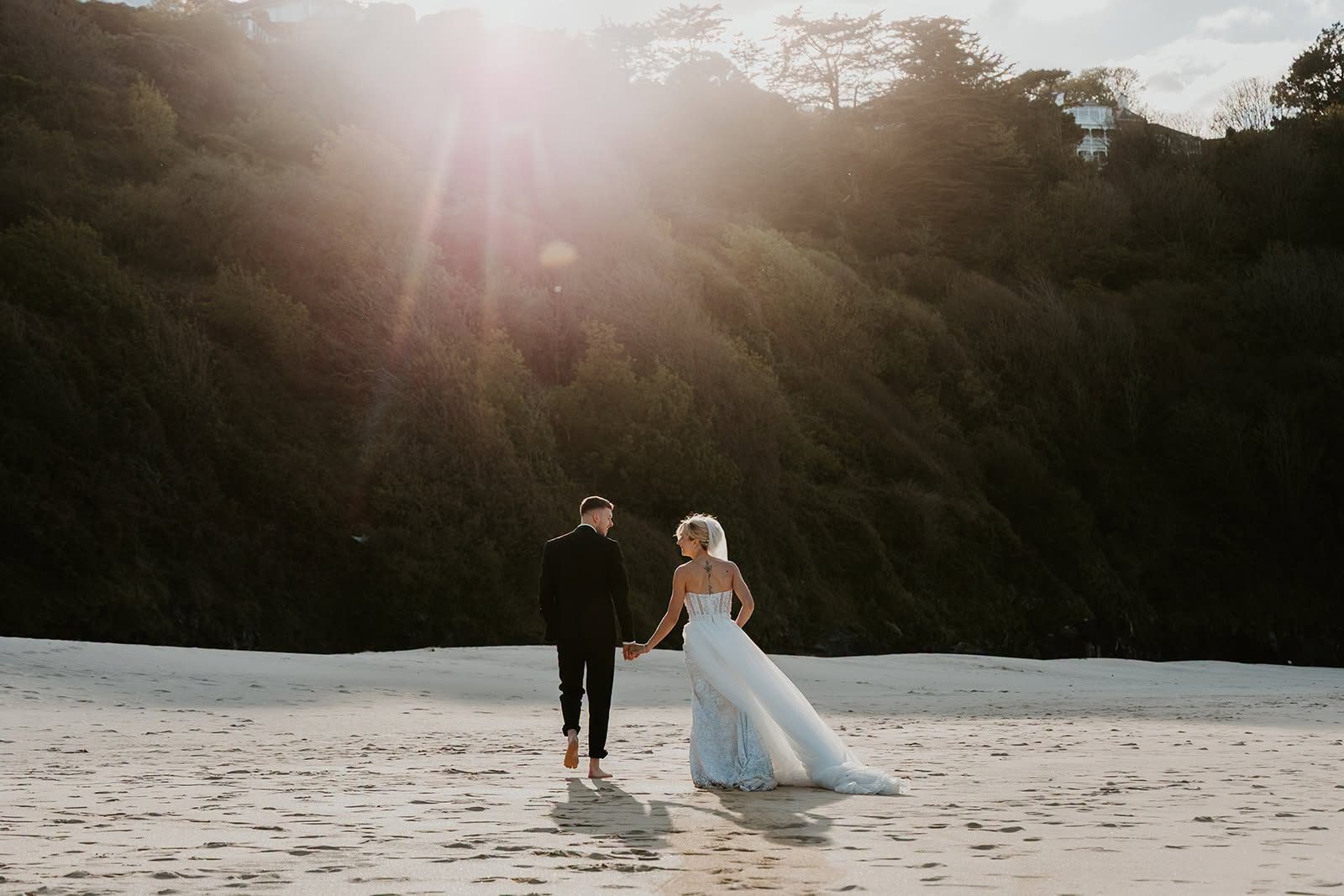 Newlyweds walking together on a sunlit beach