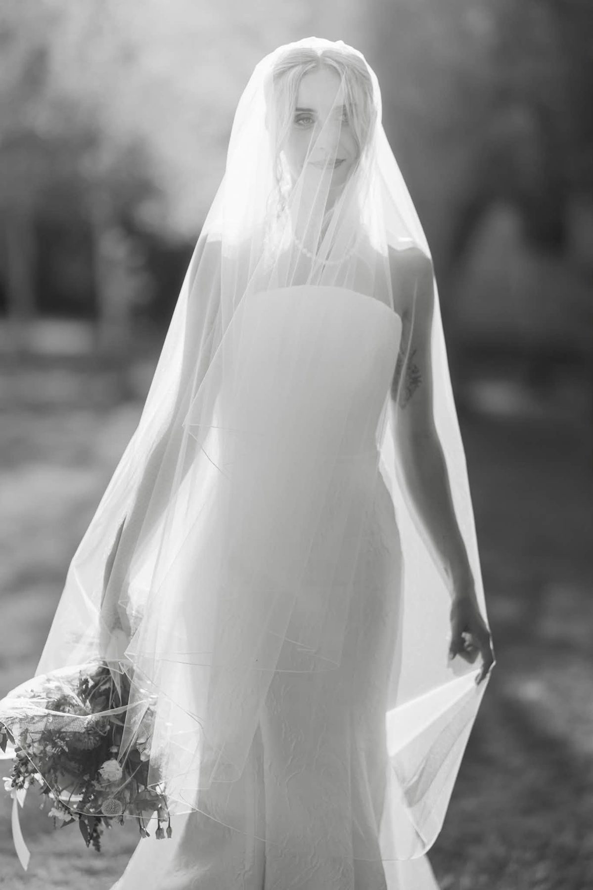 Black-and-white bridal portrait beneath a veil