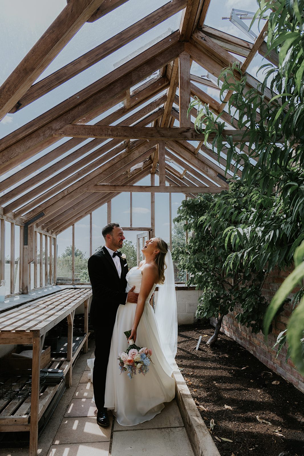 Hannah and James laughing together in the glasshouse at Deer Park