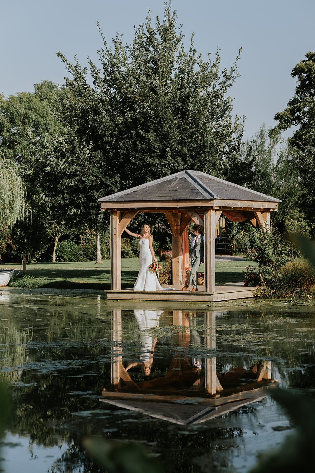 India and Cam beside the lake in the pergola, reflected in the water