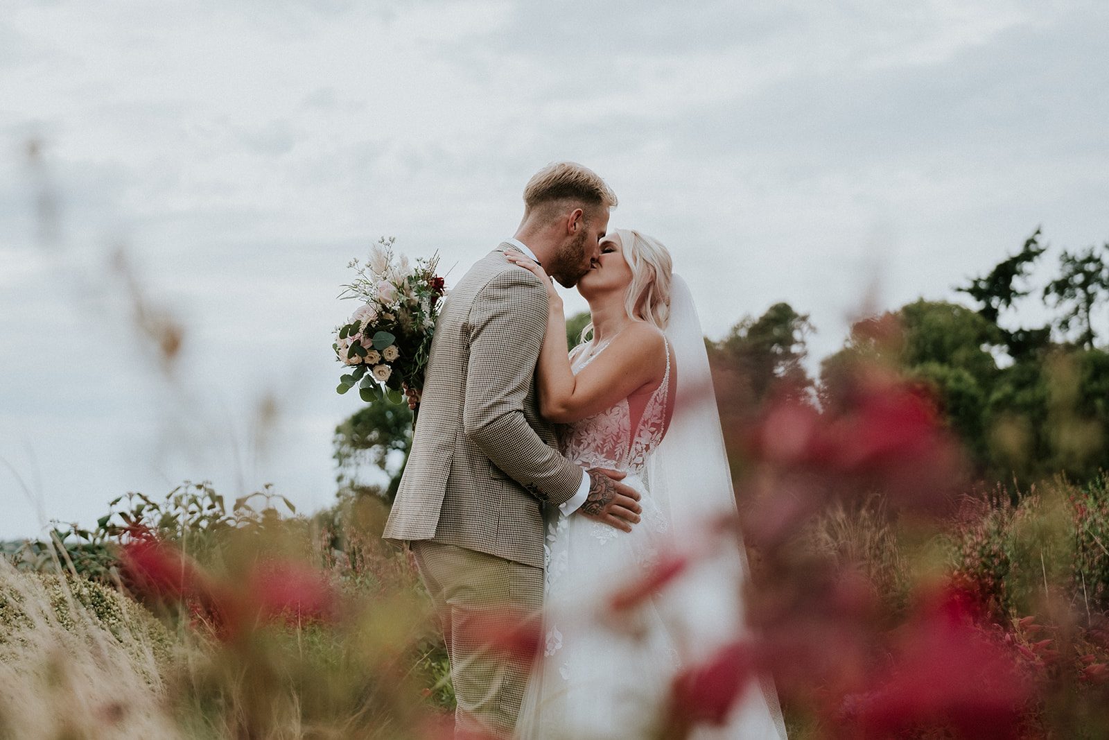 Izzie and Todd kissing among flowers in the field