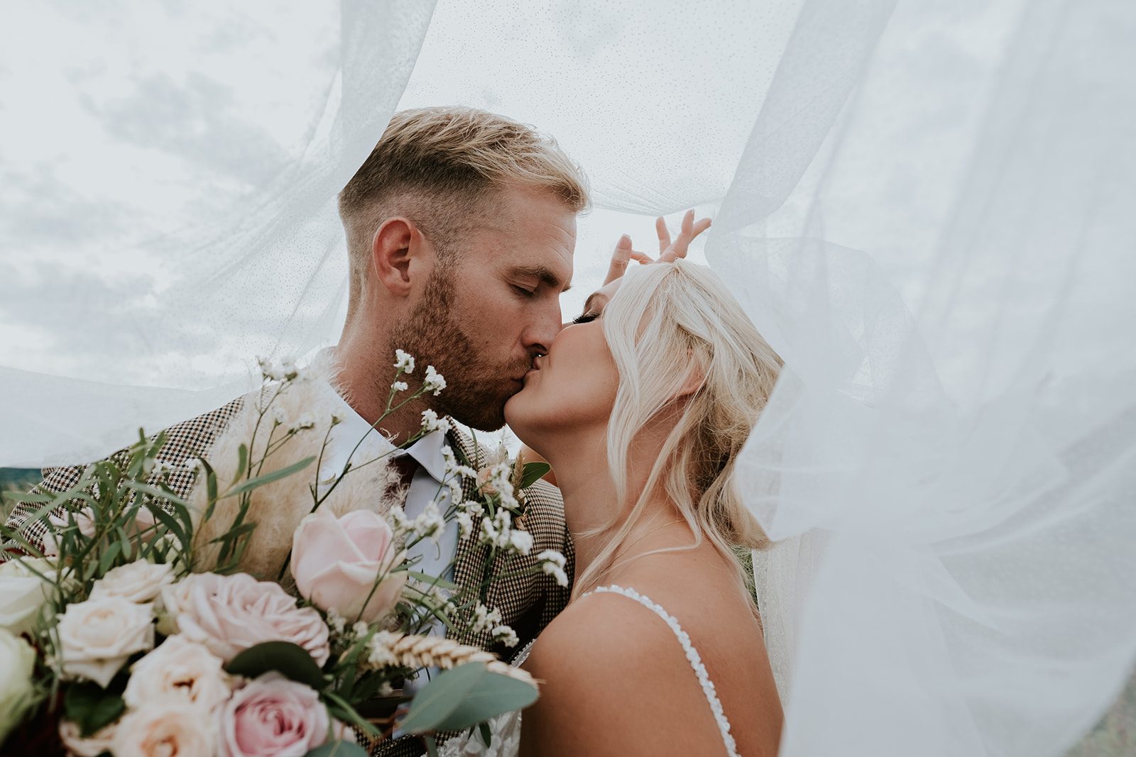 Izzie and Todd kissing beneath the veil