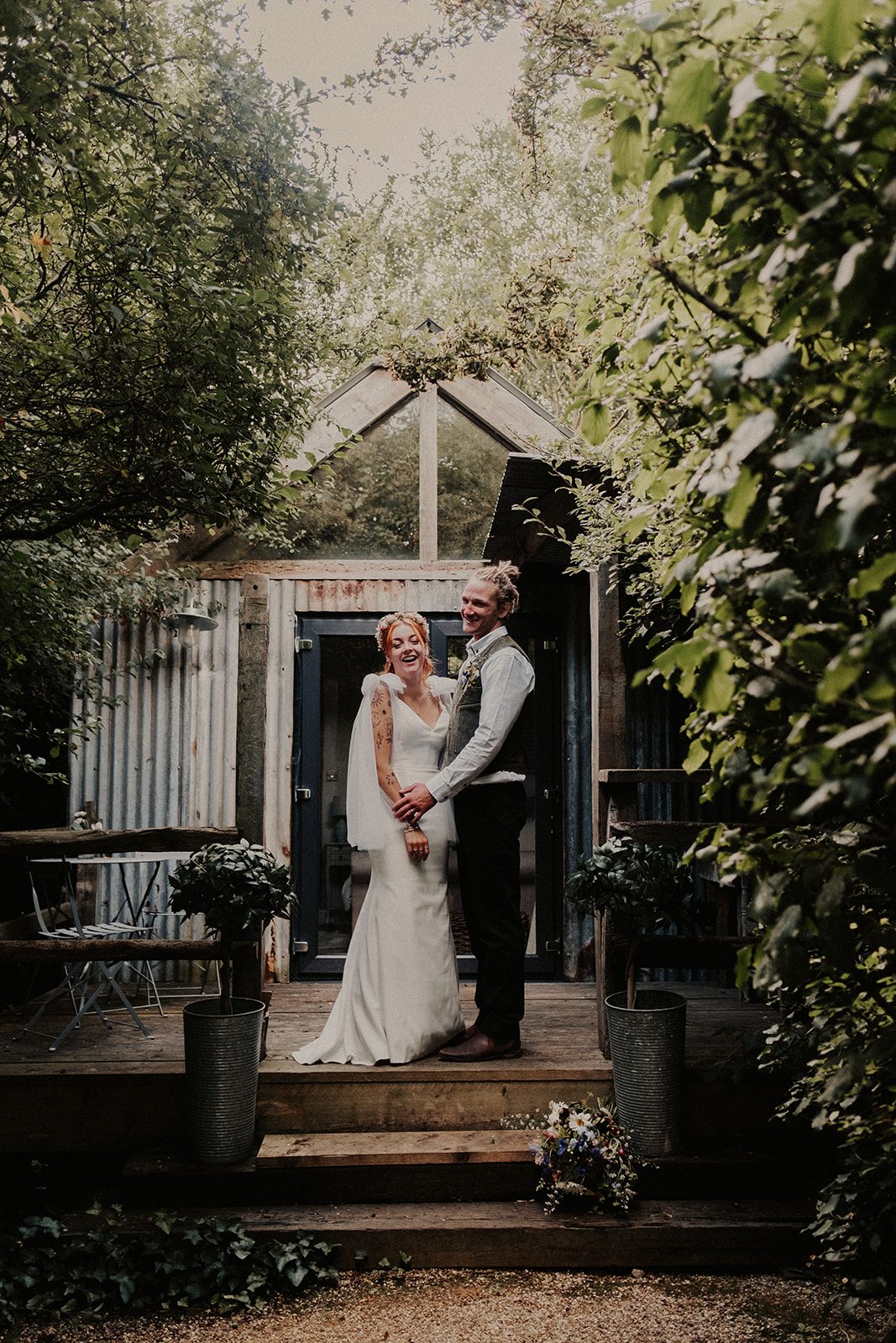 Keri and Jason laughing together on the wooden steps at Old Oak Farm