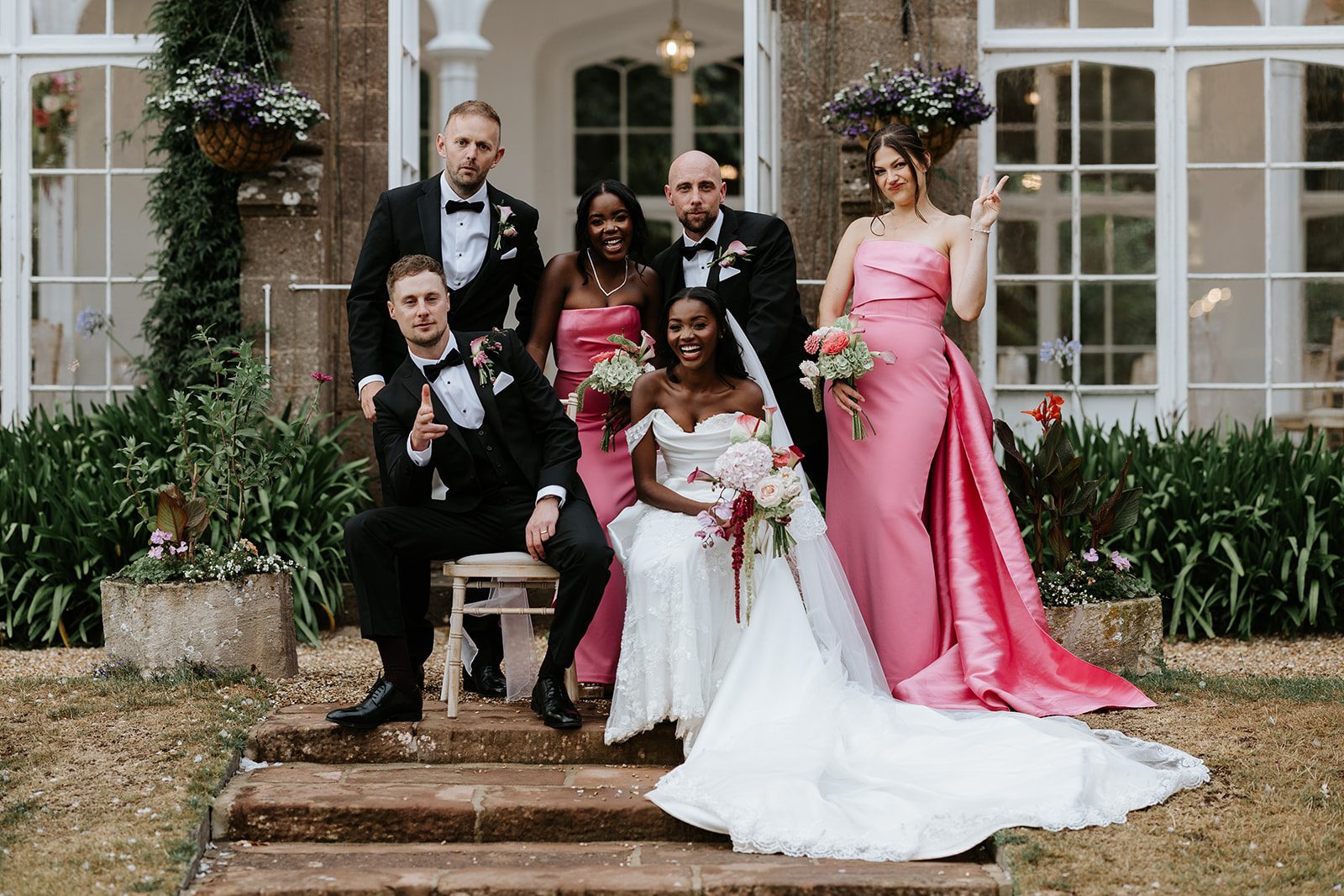 Loretta and Andy having fun with their wedding party on the steps at St Audries Park