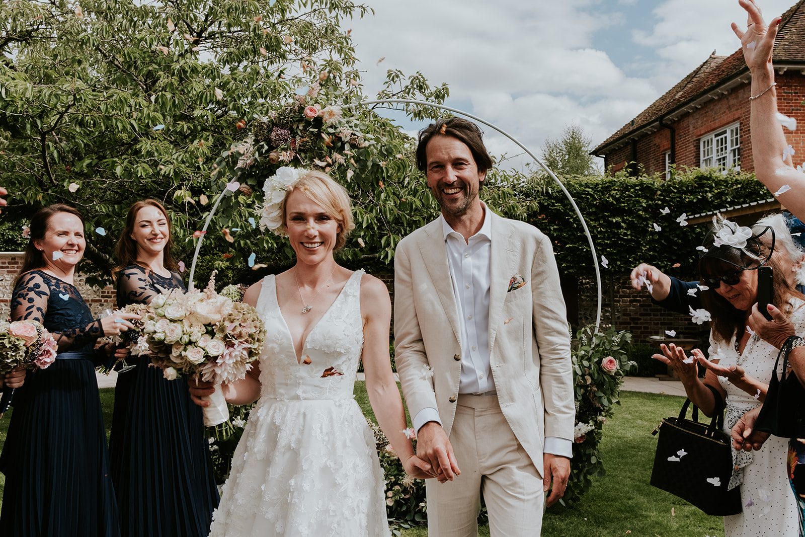 Mel and Justin smiling beneath their wedding confetti