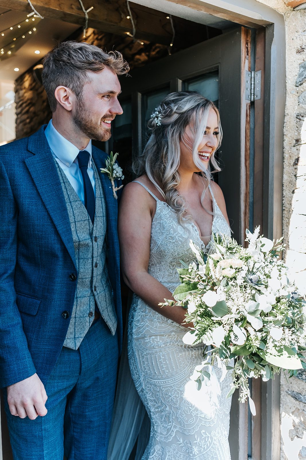 Morwenna and Macca laughing together in a barn doorway at Trevenna