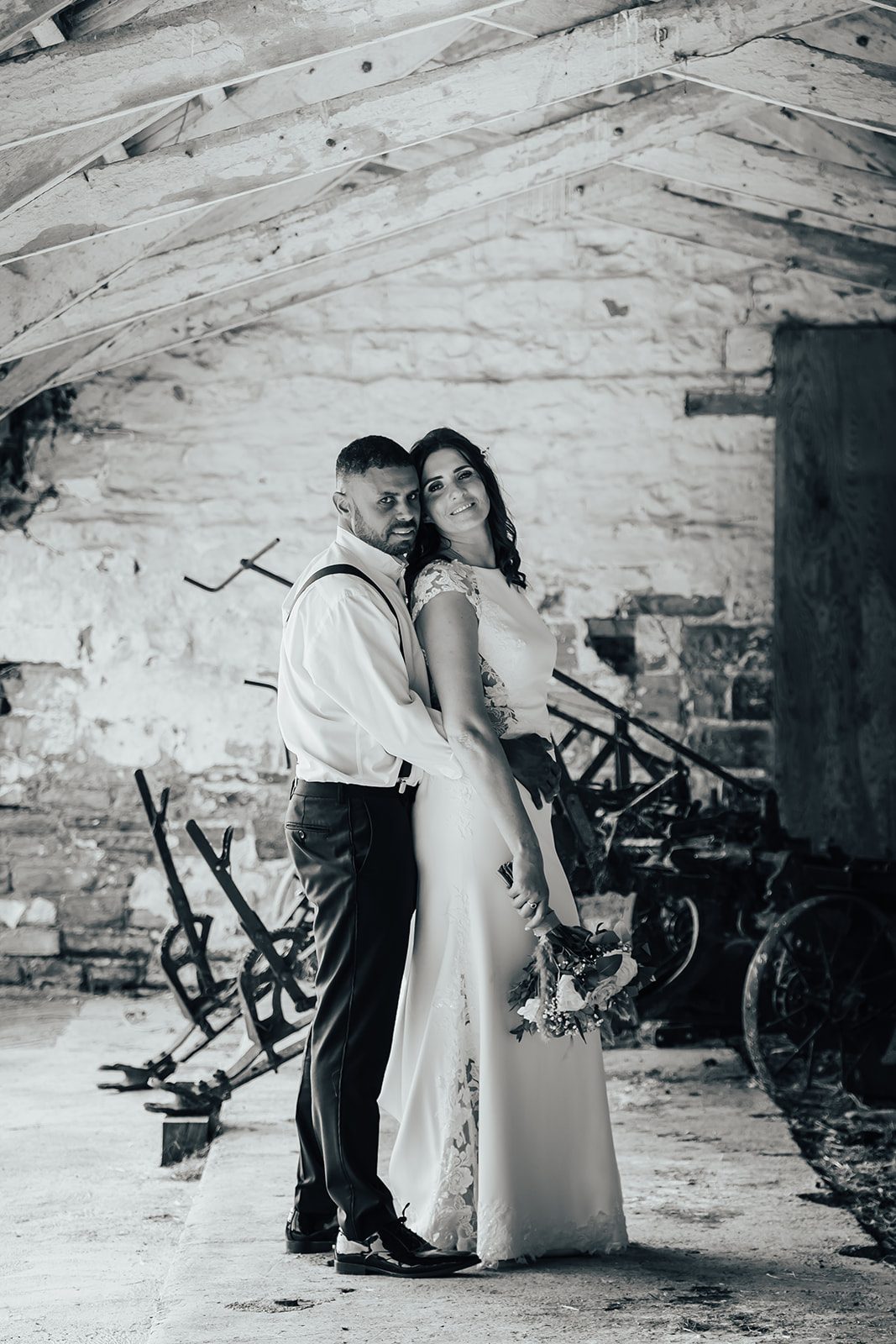 Stacey and Daniel together beneath the barn beams, in black and white